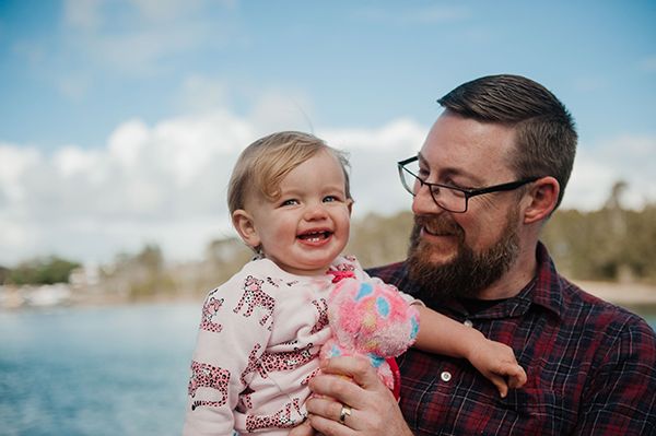 A man holding a baby both laughing and smiling 