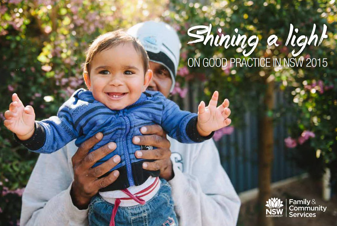 A father holding up his infant child who is very happy with a large smile. 